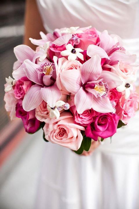 robe de mariée beige, dorée et un bouquet de lys roses et de roses rose, un feuillage