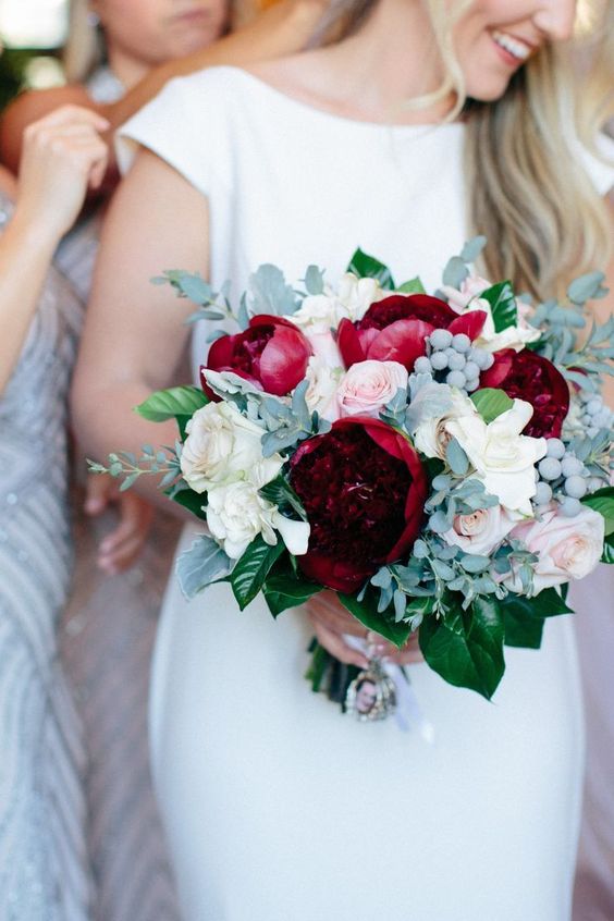 robe de mariée blanche bustier et un bouquet de pivoines rouges, de fleurs dans les tons roses et un feuillage