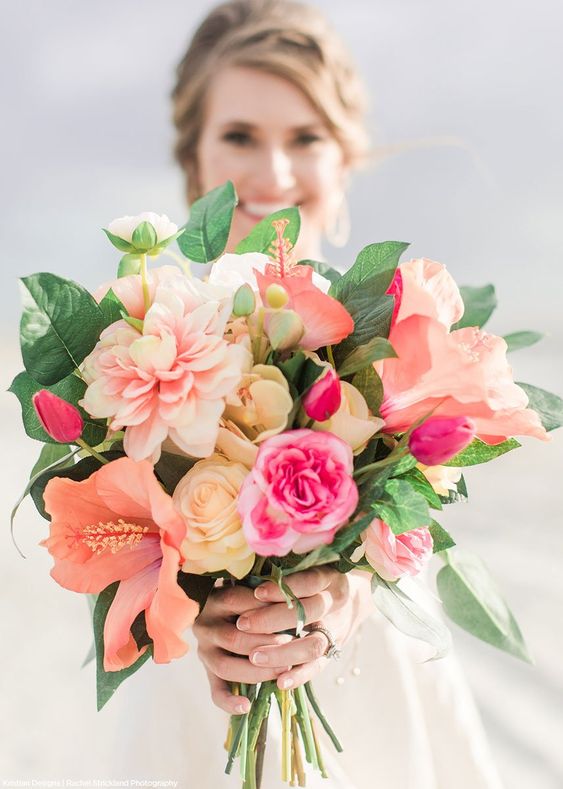 robe de mariée blanche et un bouquet de tulipes roses, des fleurs roses et un feuillage