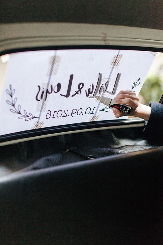 Décoration de l'arriére d'une voiture des mariés avec un marqueur blanc