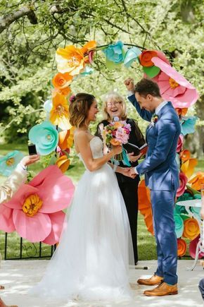 échange des voeux des mariés avec une arche de grandes fleurs de couleurs vives