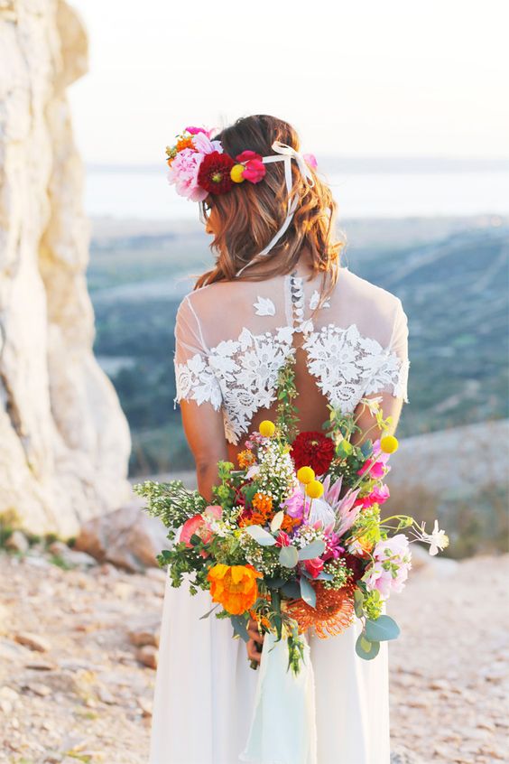 Robe de mariée de style bohème chic avec un headband de fleurs de couleurs vives et un bouquet de fleurs fraiches et vives